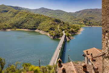 Naklejka premium A view of Lake Turano, from the village of Castel di Tora, Rieti, Lazio, Italy. The bridge crossing the lake, surrounded by green mountains. Blue sky in summer.