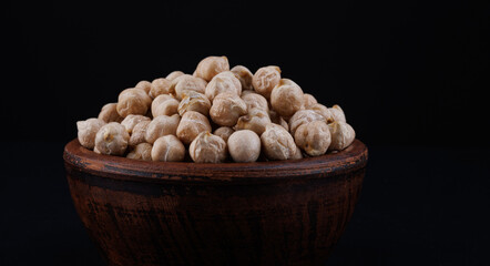 Clay cup with chickpeas on a beautiful illuminated red background.