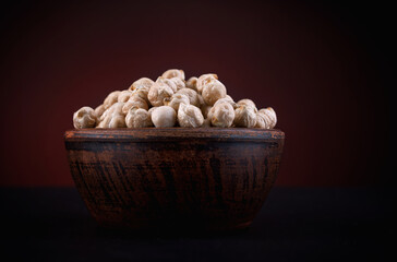 Clay cup with chickpeas on a beautiful illuminated red background.