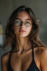 A young woman with glasses looking at the camera