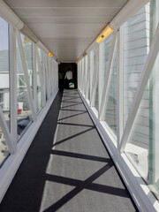 Obraz premium Bridge corridor walkway in airport with morning sunlight.