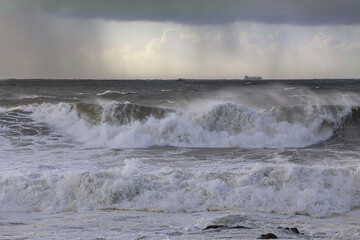 Stormy breaking waves in a rainy evening