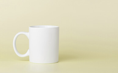 white cup for tea or coffee on a yellow background