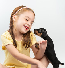 Child girl play with puppy