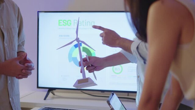 diversity team brainstorming focused on ESG (environment,social,governance)  and renewable energy to reduce pollutions in a sustainable green office at night