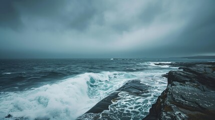 Tranquil ocean by the rugged shore under overcast skies