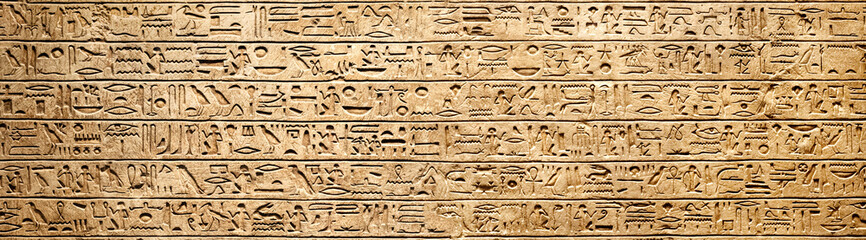 Old Egyptian hieroglyphs on an ancient background. Wide historical background. Ancient Egyptian hieroglyphs as a symbol of the history of the Earth.