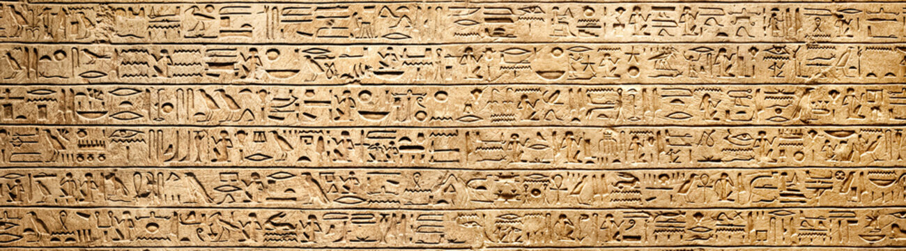 Old Egyptian hieroglyphs on an ancient background. Wide historical background. Ancient Egyptian hieroglyphs as a symbol of the history of the Earth.