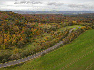 View from above of a landscape with trees and a road in autumn