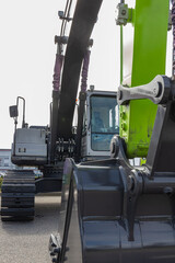 A modern excavator equipped with hydraulic attachments, such as buckets and breakers, efficiently digs trenches, demolishes structures, and handles materials