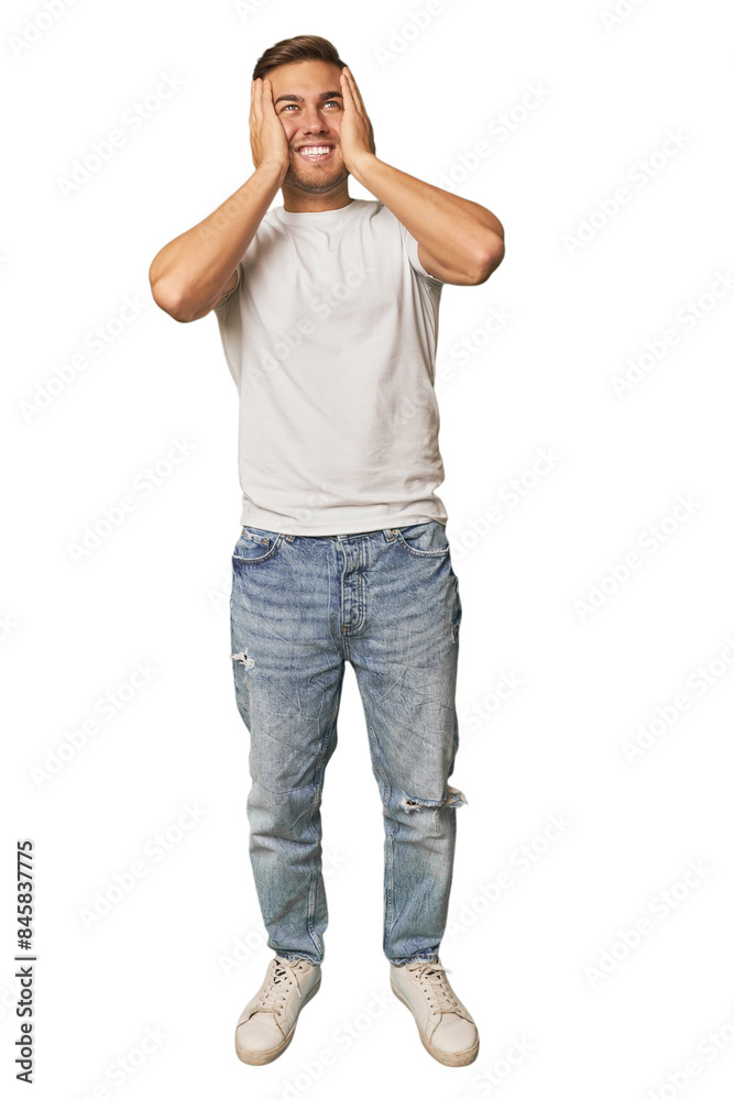 Poster full body portrait of a man in studio laughs joyfully keeping hands on head. happiness concept.