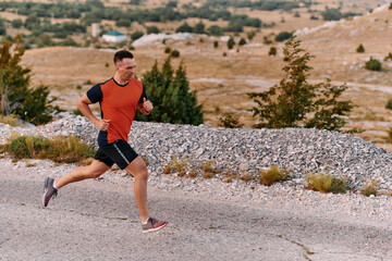 Determined Athlete Running Through Rugged Mountain Terrain at Sunrise.