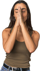 Fototapeta premium Hispanic young woman holding hands in pray near mouth, feels confident.
