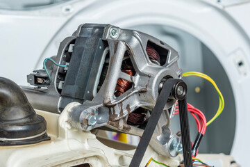 Fototapeta premium Close-up of washing machine motor with drive belt. Concept of washing machine motor repair.