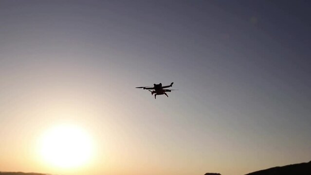 Drone flying against sunset sky