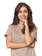 Fototapeta premium Middle Eastern woman in studio smiling happy and confident, touching chin with hand.