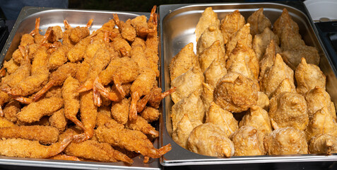 Fried shrimp, breaded prawns and fried crispy dumplings. Golden brown samosas ready to eat