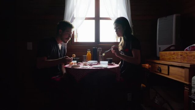 Couple in Pajamas Having Breakfast in a Rustic Wooden House. Couple Enjoying Breakfast in a Cozy Cabin. Morning Routine 