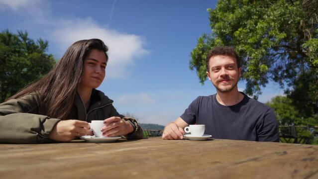 Couple Enjoying Coffee Together in a Scenic Outdoor Setting. Lovers Chatting Over Coffee Outdoors. Joyful Conversation
