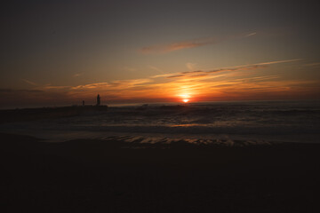 Sunset in the ocean by the lighthouse
