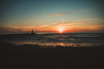 Sunset in the ocean by the lighthouse