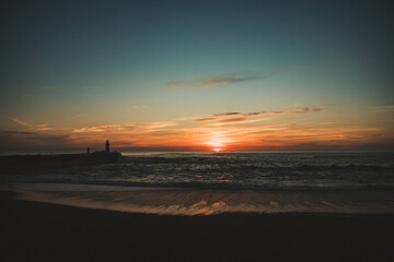 Sunset in the ocean by the lighthouse