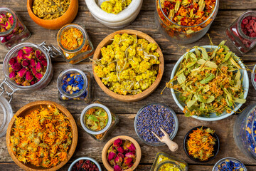 Assortment of dry herbal and berry tea on a wooden background. Tea party concept. medicinal herbs. Healing herbs.Alternative medicine.Linden, calendula, cornflowers, marigold, tansy, tea rose.