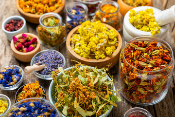 Assortment of dry herbal and berry tea on a wooden background. Tea party concept. medicinal herbs. Healing herbs.Alternative medicine.Linden, calendula, cornflowers, marigold, tansy, tea rose.