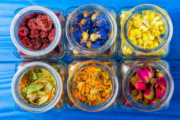 Assortment of dry herbal and berry tea on a wooden background. Tea party concept. medicinal herbs. Healing herbs.Alternative medicine.Linden, calendula, cornflowers, marigold, tansy, tea rose.