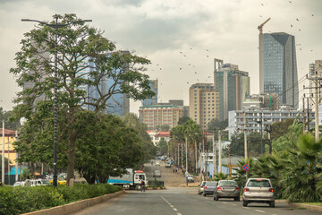Obraz premium Wide avenue and the road full of cars with rapidly developing downtown of central business district of ethiopian capita,l Addis Ababa, Ethiopia