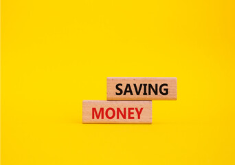 Saving Money symbol. Concept word Saving Money on wooden blocks. Beautiful yellow background. Business and Saving Money concept. Copy space