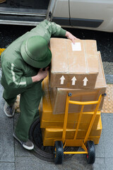 delivery courier worker with packages boxes with boxcar for delivering in city