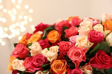 Beautiful bouquet of colorful roses on beige background, closeup