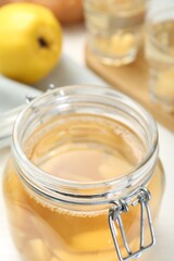 Delicious quince drink in glass jar on table, closeup