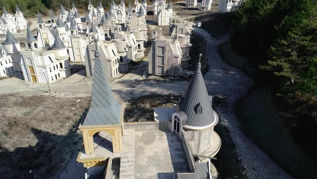 Houses which are being built in style of mini French chateaux, are all three storeys tall with a round corner turret and square tower above their entrances. Aerial, fly over