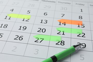 Timetable. Calendar page with marked dates and pen, closeup