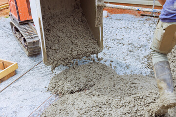 Concrete is poured using dumper tracked wheelbarrow at construction site