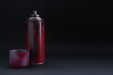 One spray paint can with cap on dark background, space for text