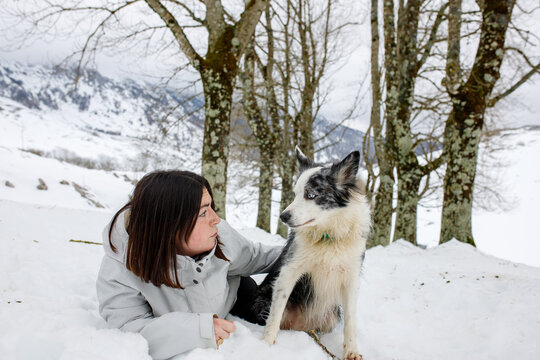 Woman and Blue Merle Border Collie in snowy nature