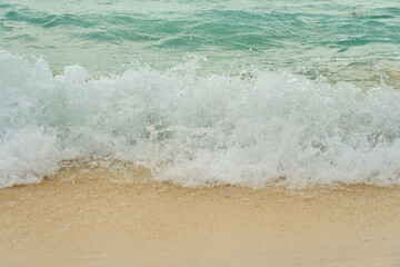 Waves and foam on a tropical sandy beach.