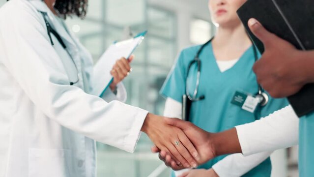 Nurse, doctor and shaking hands for healthcare meeting, support and welcome with introduction to staff. Medical people with group handshake for teamwork, hello or onboarding in hospital or clinic
