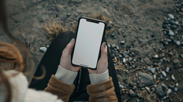 a top view of a woman holding a phone with a white screen