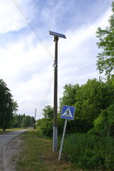 Solar battery on a pole in the village. Autonomous pedestrian crossing.