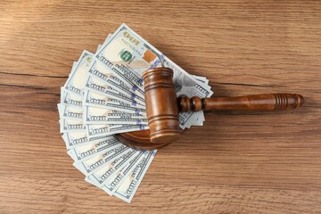 Judge's gavel and money on wooden table, top view