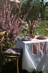 Stylish table setting with beautiful spring flowers in garden