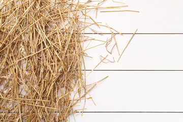 Dried straw on white wooden table, top view. Space for text