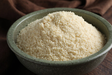 Fresh almond flour in bowl on wooden table, closeup