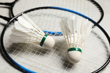 Feather badminton shuttlecocks and rackets on gray background, closeup