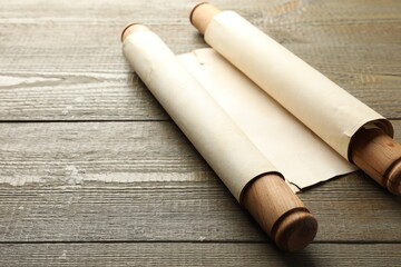 Sheet of old parchment paper with handles on wooden table, space for text
