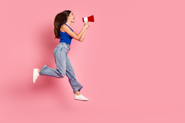 Full length photo of cheerful pretty lady dressed blue top jumping high screaming toa empty space...